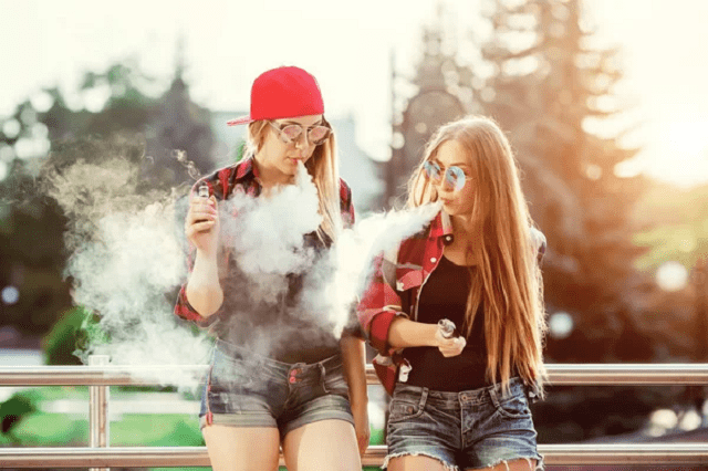 2 jeunes femmes fumant cigarette électronique
